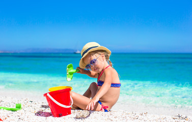 Adorable little girl playing with beach toys during tropical