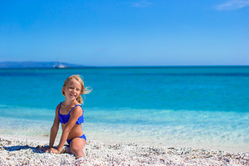 Happy little sporty girl on white tropical beach