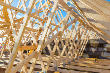 New residential construction home framing against a blue sky 