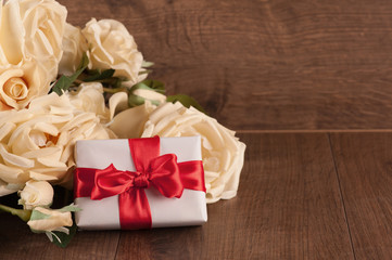 Bouquet of white roses and gift box