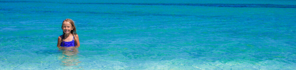 Adorable little girl having fun during tropical vacation