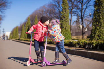 Little happy girls with scooter outdoors