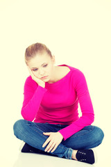 Young sad woman sitting.