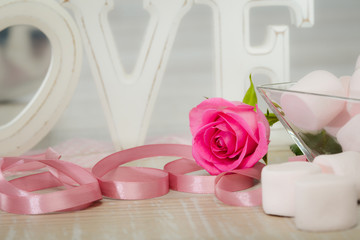 love symbol still life with letters, heart, ribbon and flowers