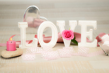 love symbol still life with letters, heart, ribbon and flowers