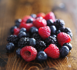 pile of fresh assorted berries on wooden table
