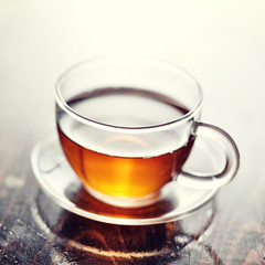 hot tea in glass cup on platter with retro filter
