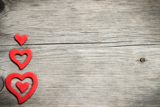 Red hearts on wood - retro background