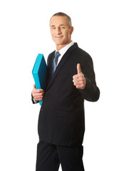 Mature businessman with ok sign holding a binder