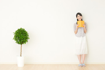 部屋で本を読む女性