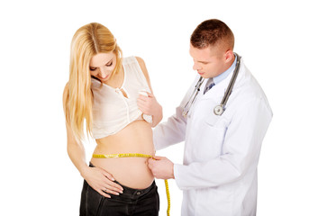 Doctor measuring pregnant woman's belly