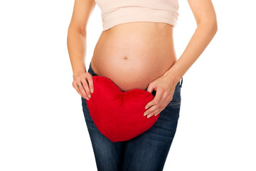 Pregnant woman with a heart pillow