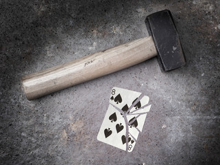 Hammer with a broken card, eight of spades