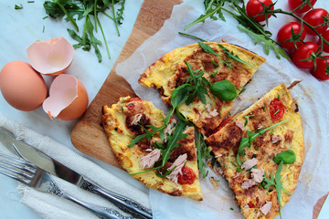 Delicious egg omelet with fresh rucola salad and tomatoes