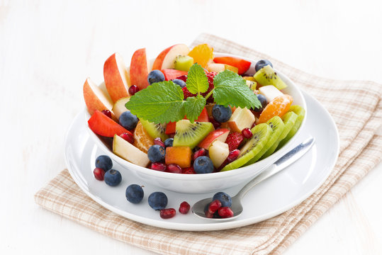 delicious fruit and berry salad in white bowl