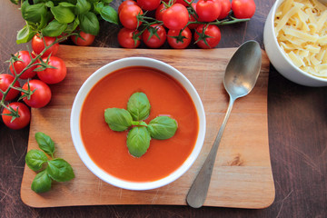 Homemade tomato cream soup on wooden board