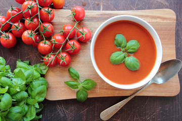 Bowl with tomato soup with basil leafs