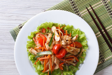 Asian chicken salad with vegetables close-up top view