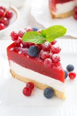 piece of cheesecake with berry jelly on a white plate, close-up