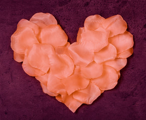 Heart from rose petals textile on grunge marsala background
