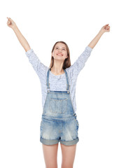 Happy young fashion girl in jeans overalls with hands up isolate