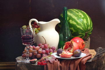 Still-life with wine, grapes, a pomegranate, a fig, a water-melo