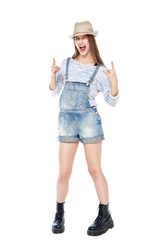 Young fashion girl in jeans overalls with horn gesture isolated