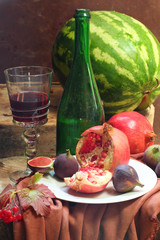 Still-life with wine, a pomegranate, a fig and a water-melon