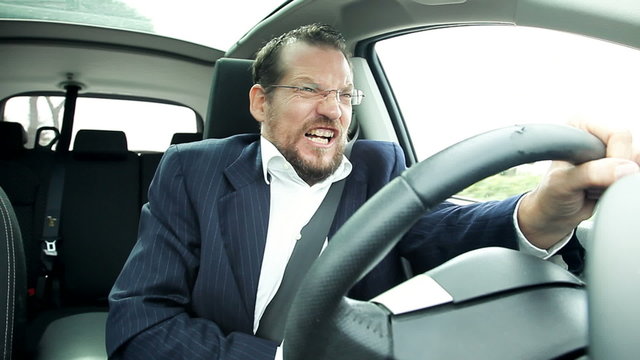 Business man driving car feeling stomach sick funny faces