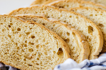 pieces of fresh homemade bread on a white towel in basket