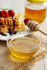 Bowl of honey on wooden table.