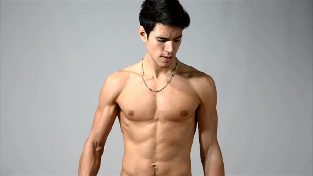 Attractive shirtless young man doing biceps curls