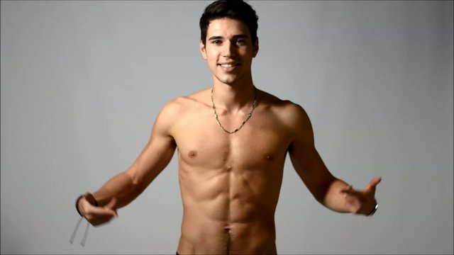 Attractive shirtless young man pointing at empty space