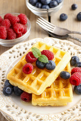Waffles with syrup raspberries and blueberries
