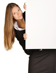 Business woman looks out from behind a blank white sheet of