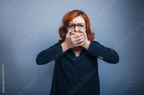 European Appearance Redheaded Girl In Glasses Covering Her Mouth