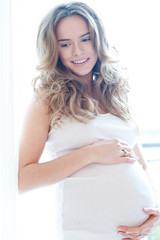 Portrait of adorable pregnant woman in white - paradise