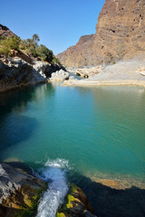 Fototapeta na wymiar Water flowing to the natural pool between the mountains in Oman