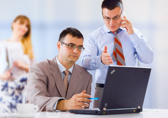 Businesspeople working on laptop in an office