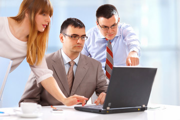 Businesspeople working on laptop in an office