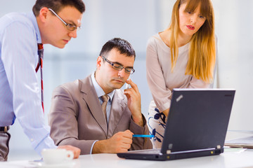 Businesspeople working on laptop in an office