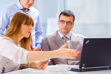 Businesspeople working on laptop in an office