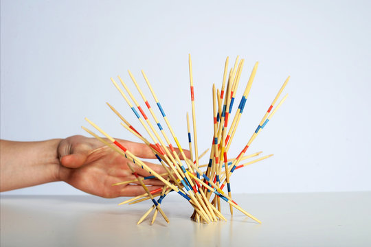 Mikadospiel iwird von der Hand losgelassen und f&auml;llt
