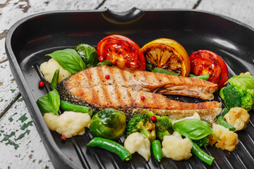grilled salmon with vegetables on a grill pan