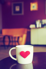 vintage color tone of  cup of coffee with red heart on the table