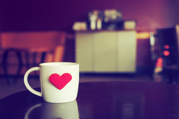 vintage color tone of  cup of coffee with red heart on the table