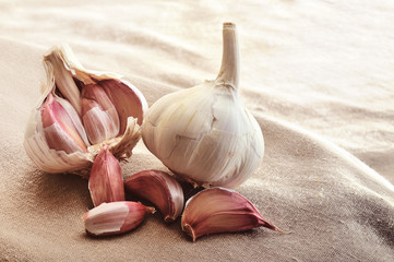 heads of garlic on brown fabric closeup