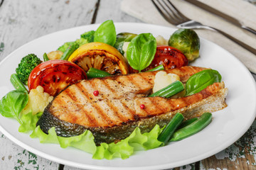 steak grilled salmon with vegetables on a plate