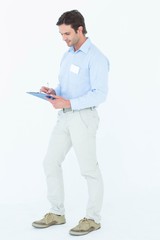 Confident businessman writing on clipboard