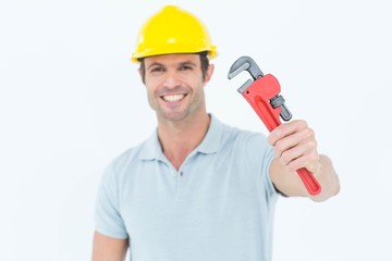 Happy carpenter holding monkey wrench
